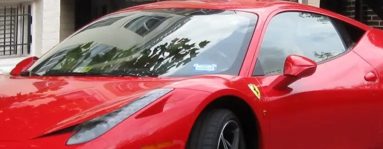 Red sports car parked in front of a garage